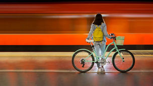 Vrouw met fiets op treinplatform