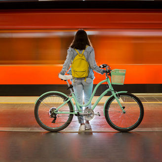 Vrouw met fiets op treinplatform
