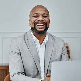 A bald man laughing wearing grey coat banner 