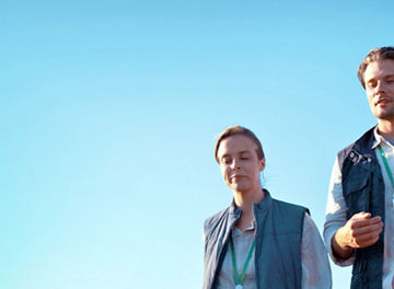 A man holding a tablet walking with women in a field
