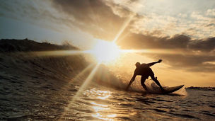 A man surfing at sunset
