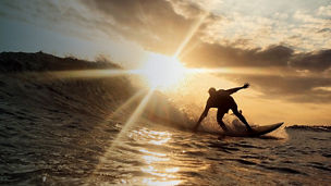 A man surfing at sunset