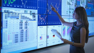 Businesswoman preparing presentation on graphical screens