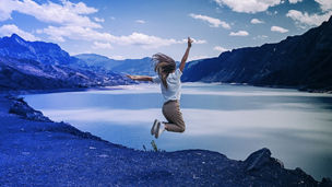 A women jumping beside a river