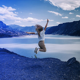 A women jumping beside a river