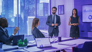 White colleagues discussing project while working with laptop in office indoors