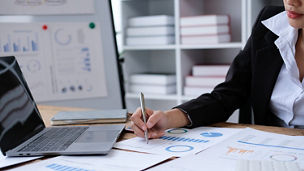 Woman taking notes near her laptop