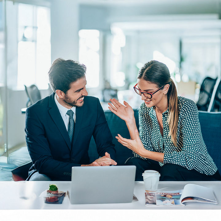  Kollegen, die gemeinsam auf einen Laptop schauen