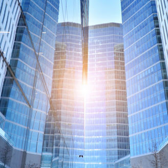 Downtown corporate business district architecture. Glass reflective office buildings against blue sky and sun light. Economy, finances, business activity concept.