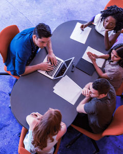 Personen am Tisch mit Laptop