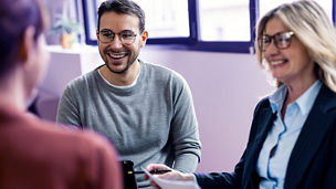 Happy businessman sitting with colleagues in office