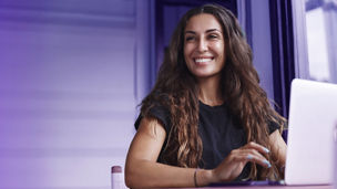Woman smiling behind laptop
