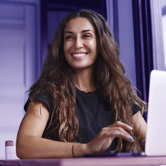 Woman smiling behind laptop