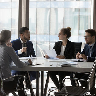Busy millennial professional group reviewing startup marketing reports, collaborating on project. Business partners negotiating on deal, discussing agreement terms on meeting in office
