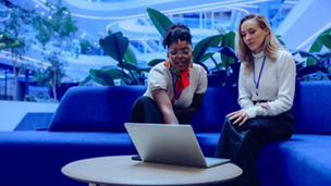 Fotografía de dos mujeres juntas observando información en una computadora