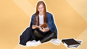 Meisje zit op de grond met een boek in haar handen.