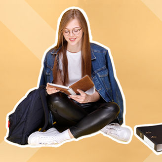 Meisje zit op de grond met een boek in haar handen.