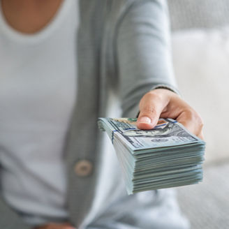 Soft focus on woman hands proposing money us dollar bills to you.