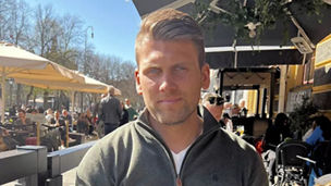 Andreas sirrer ved en uteservering i solen 