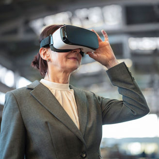 Female CEO uses virtual reality technology for visualizing upgrades in manufacturing. Innovations in training methods and safety by AI smart glasses use.