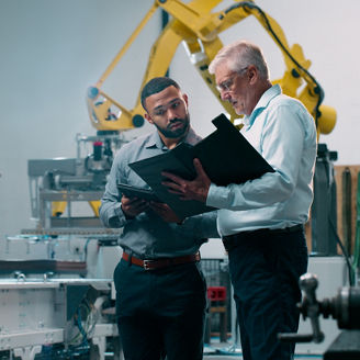 Robotics, people and engineer collaboration plans with industrial teamwork and working in warehouse. Factory, engineering and futuristic work of manufacturing management with talk for cnc automation