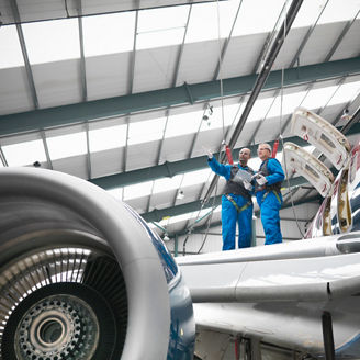 Fotografía de dos ingenieros aeroespaciales inspeccionando un avión