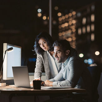Fotografía de dos colegas trabjando de noche en la oficina