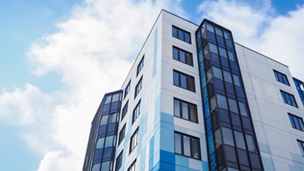 An affordable housing apartment block against a blue and cloudy sky