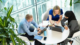 People sat around a table in an indoor office space