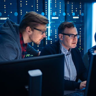 Employees discuss data on a screen