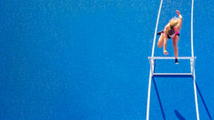 Athlete crossing hurdle banner