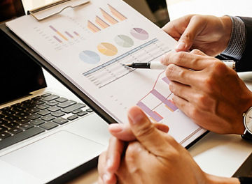 Business concept. Business people discussing the charts and graphs showing the results of their successful teamwork. Selective focus.