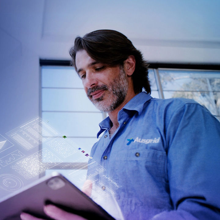 Ausgrid technician looks at procurement data on an AI assistant built with KPMG's KymChat 