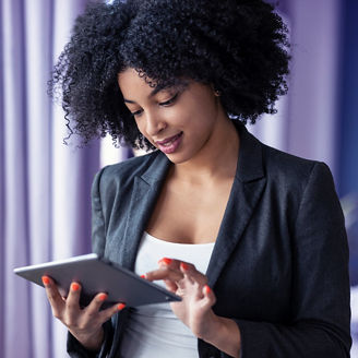 Portrait of smart afro young entrepreneur woman using her digital tablet while standing in the office at home.