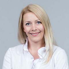 Porträt von Barbara Lauß vor einem hellgrauen Hintergrund