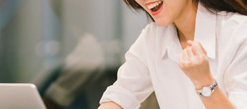 Beautiful Asian girl celebrate with laptop, success or happy pose, education or technology or startup business concept, modern office or living room with copy space