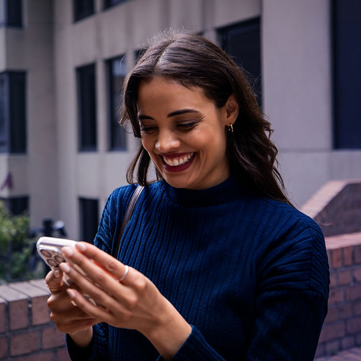 Woman holding phone and smiling