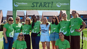 KPMG colleagues smiling for a photo in front of the start point for the KPMG Big Walk Manchester
