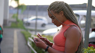 A black woman looks at her phone