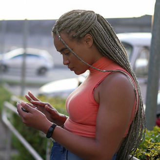 A black woman looks at her phone