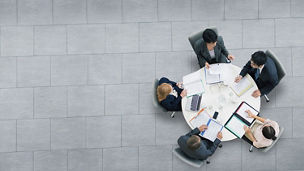 Aerial view of five business people doing meeting on round table