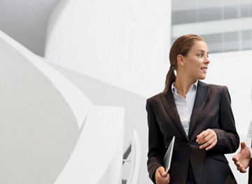 Two people walking together in an office building