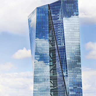 Tall blue glass building against sky