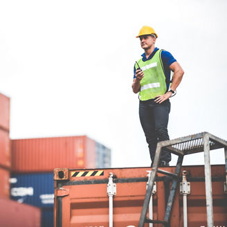 foreman worker manager working outdoor site, cargo container site, control plan working, working with safety equiments, helmet safety vest, technology walkie talkie concept.pointing finger