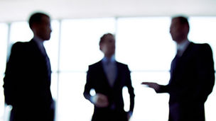 Colleagues meeting to discuss their future financial plans, only silhouettes being viewed