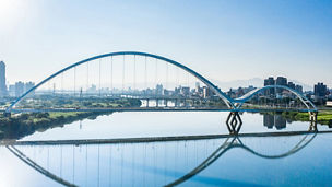 Bridge shadow reflected in river water