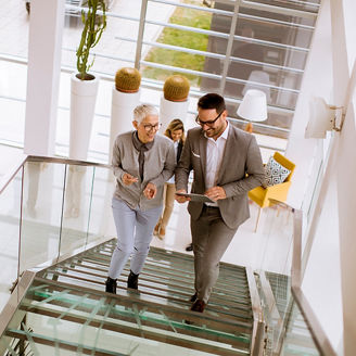 Businessmen and businesswomen walking and taking stairs in an office building