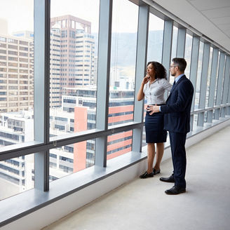 Portrait Of New Business Owners By Empty Office Window