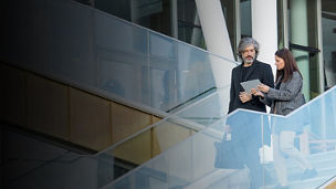 Business man and woman discussing something while walking downstairs