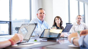 business people discussing in a meeting room with laptops on table